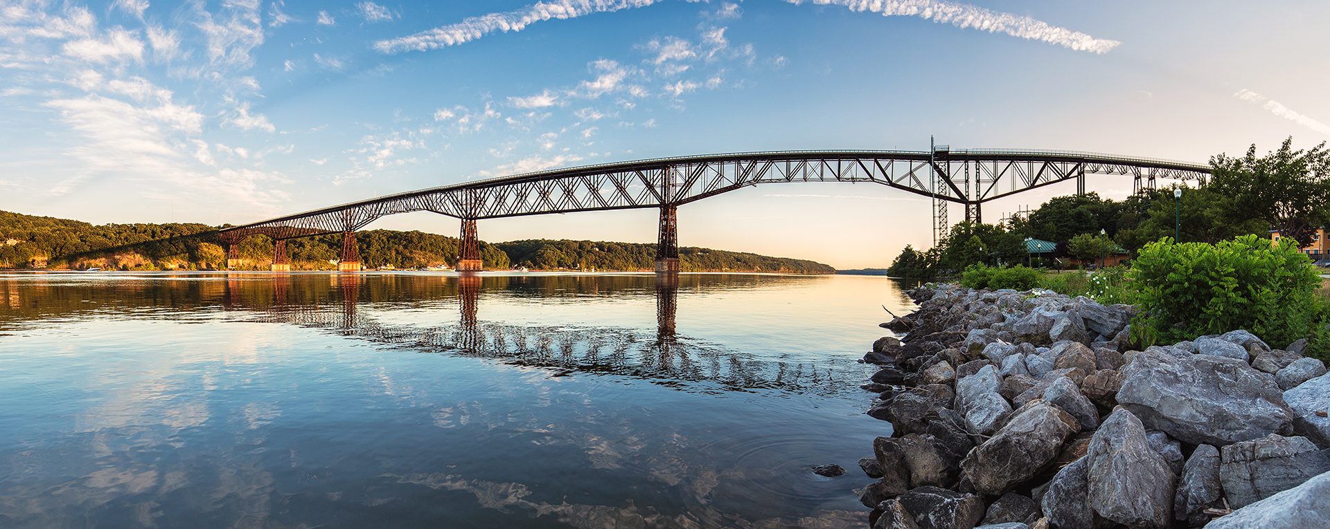 The Hudson River and a steel bridge at sunset in the Hudson Valley, NY — sell your house fast for cash