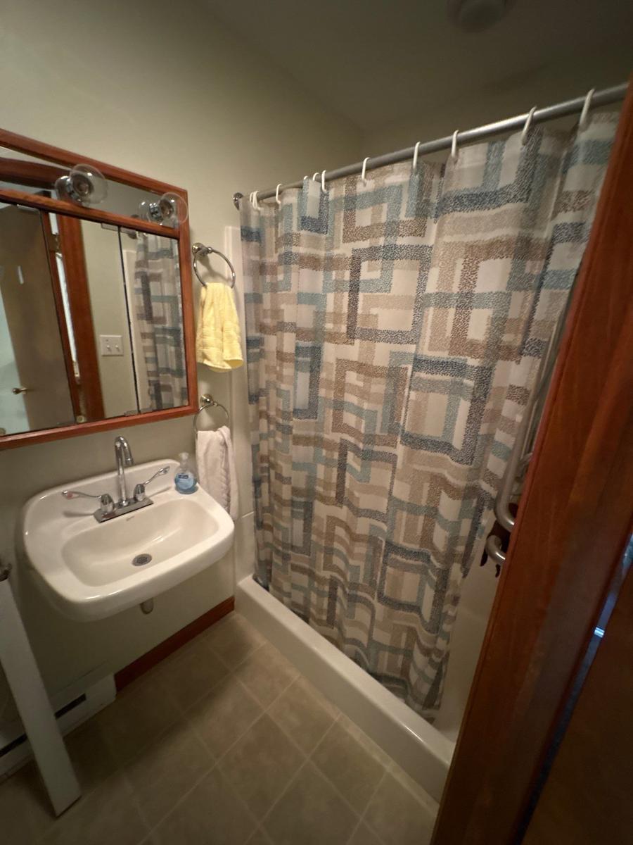 Dallas NY bathroom before — original fixtures, wood-trim mirror, functional but dated