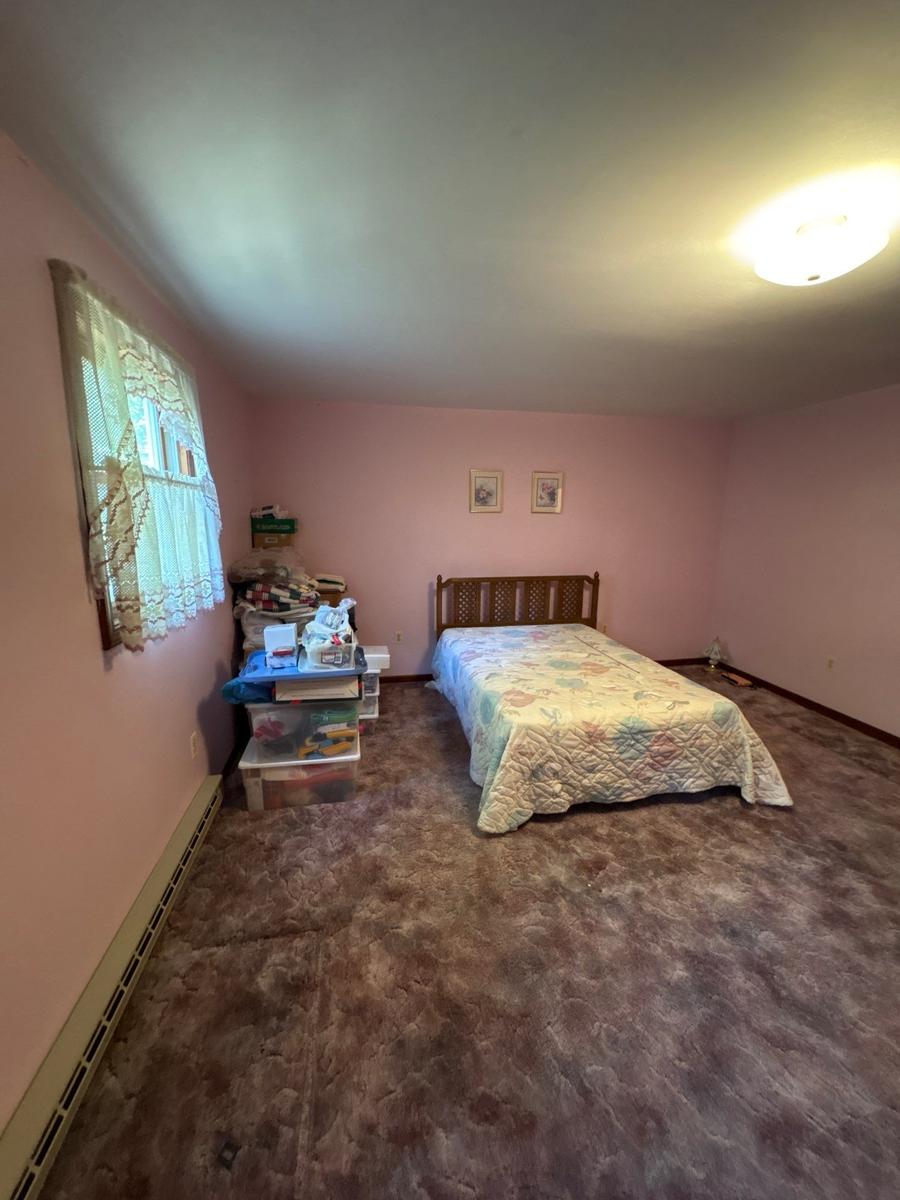 Dallas NY bedroom before — pink walls, worn carpet, original 1980s condition