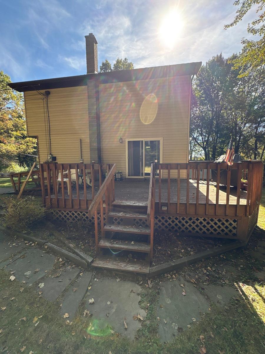 Dallas NY rear deck and exterior before — aging wood deck, wooded lot