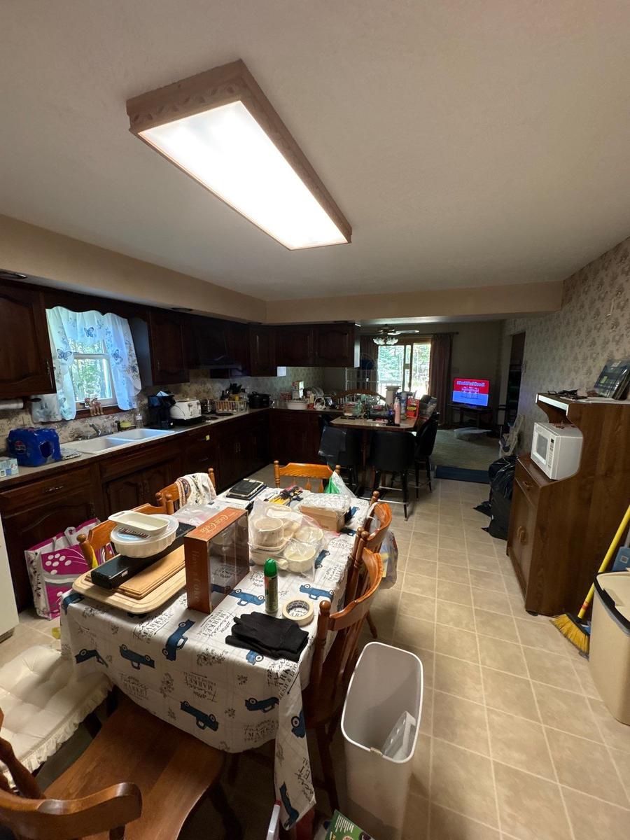 Dallas NY home kitchen before — dark walnut cabinets, dated finishes, cluttered