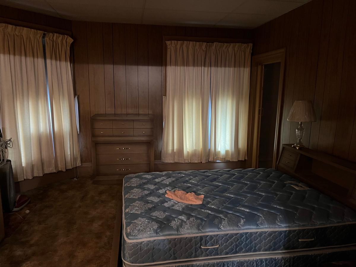 Erie NY master bedroom — dark wood paneling, full set of original furnishings, heavy curtains