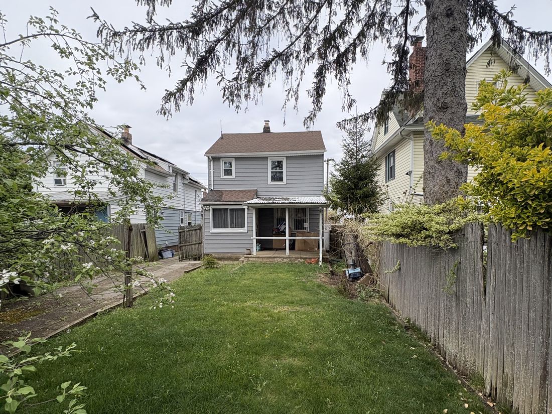 Rear yard of the Hempstead colonial, enclosed by the fencing that needed full replacement