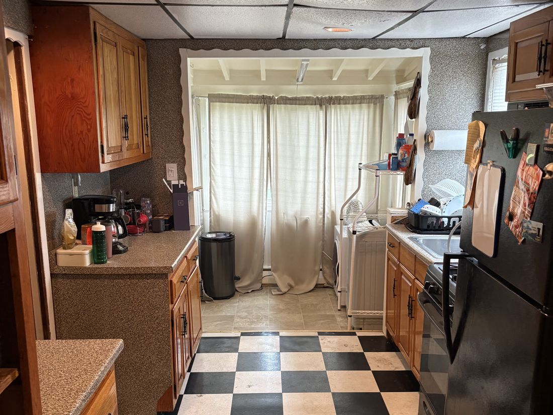 Dated Hempstead kitchen with drop ceiling and checkerboard vinyl flooring, requiring a full gut