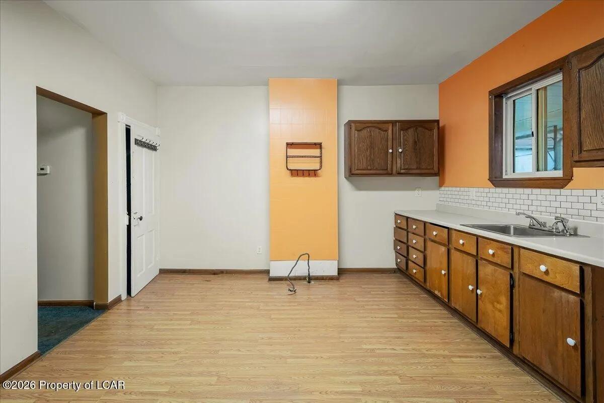 White Plains unit kitchen after — cleared, original cabinets retained, LVP flooring