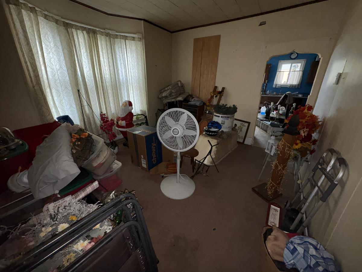 White Plains unit living room before — cluttered with personal belongings