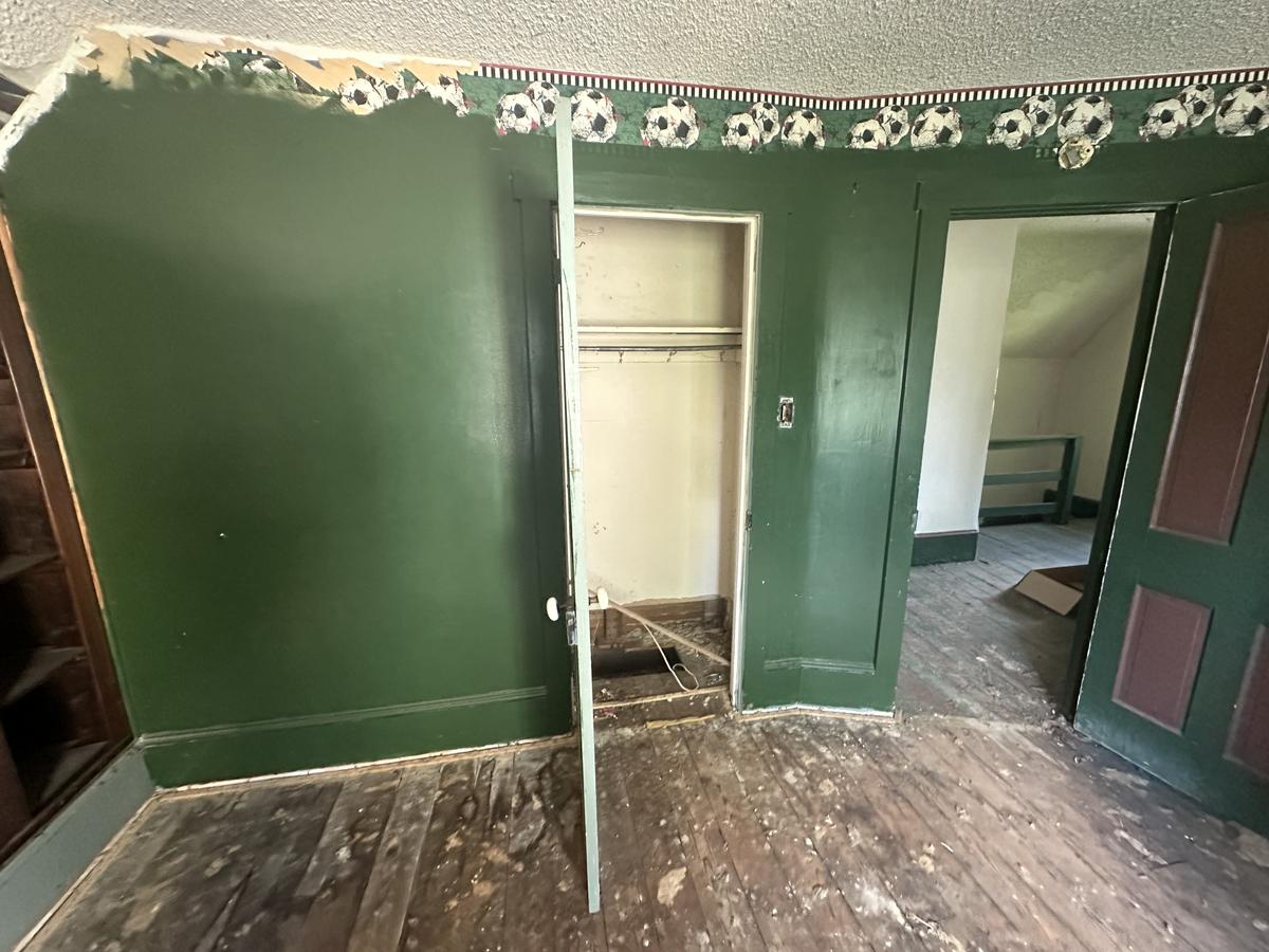 Victorian upper floor before — green paint, original doors, deteriorated hardwood floors